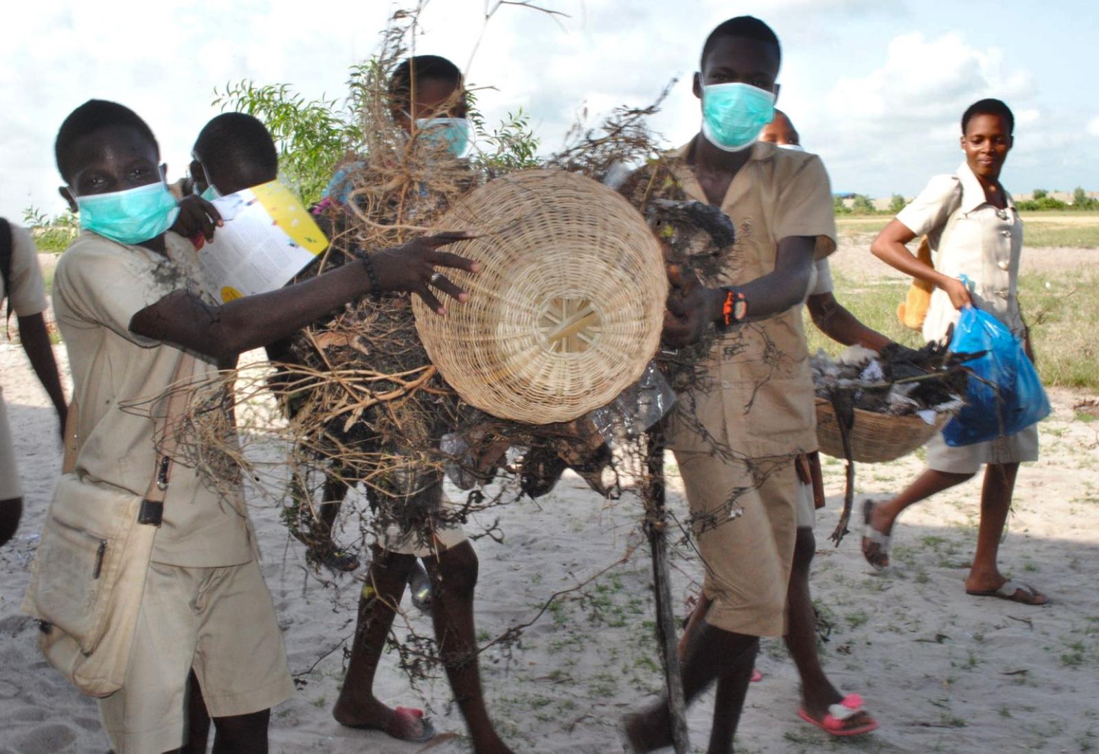 People holding a basket full with litter and twigs