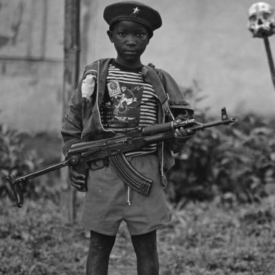 Small boy carrying big weapon. 