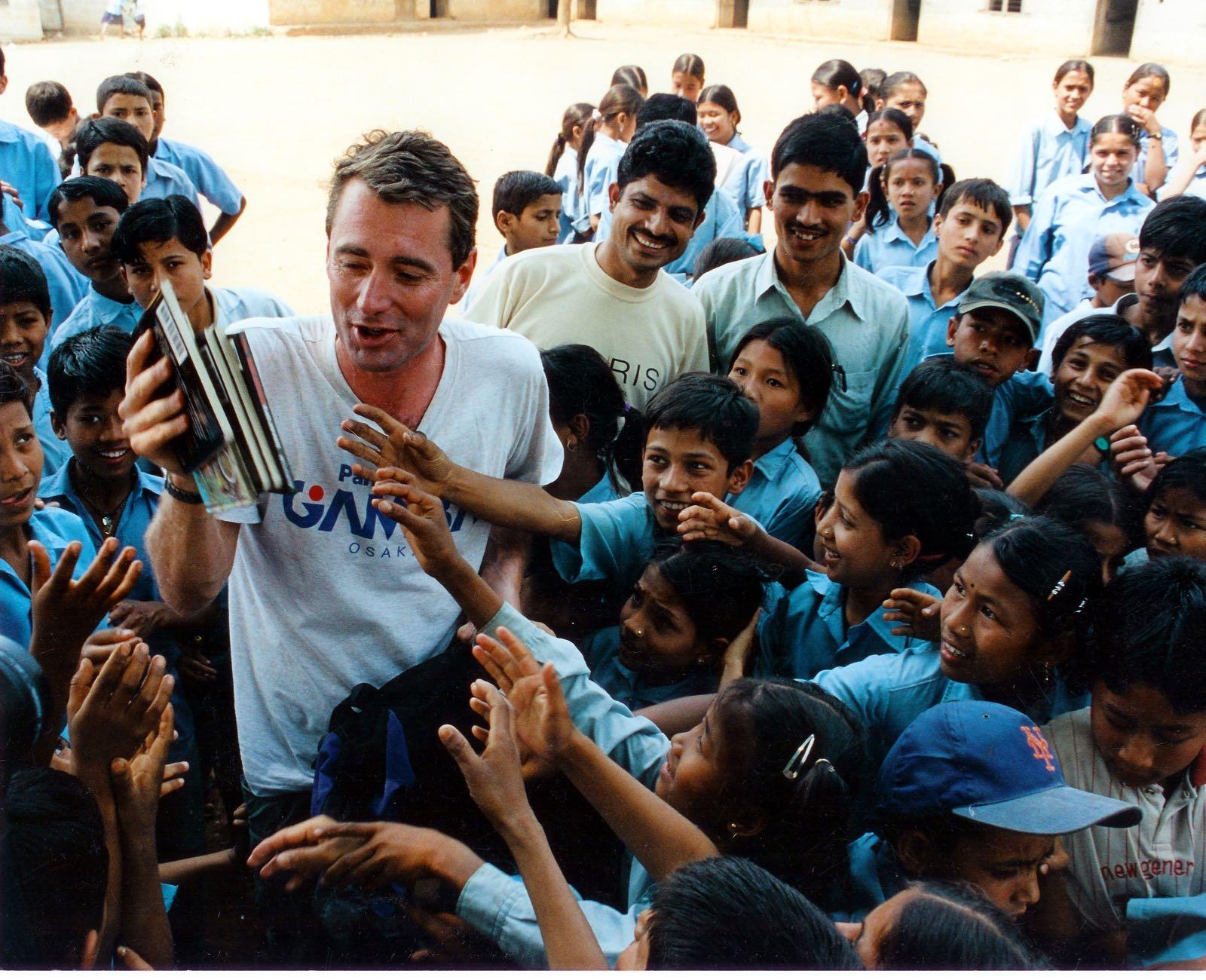 John Wood handing out books to Nepali children