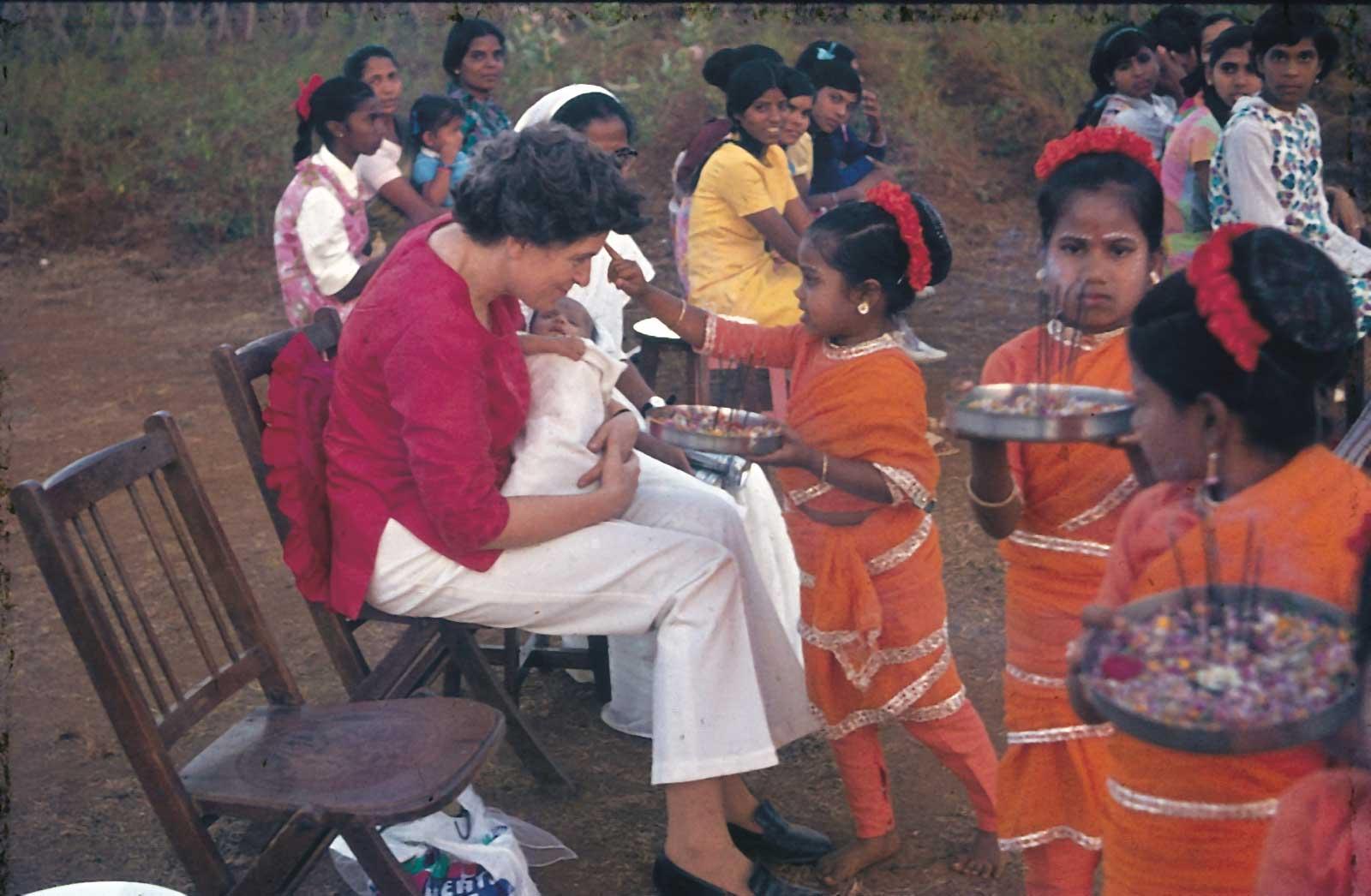 Rosi being welcomed with flower garlands and puja by children in India