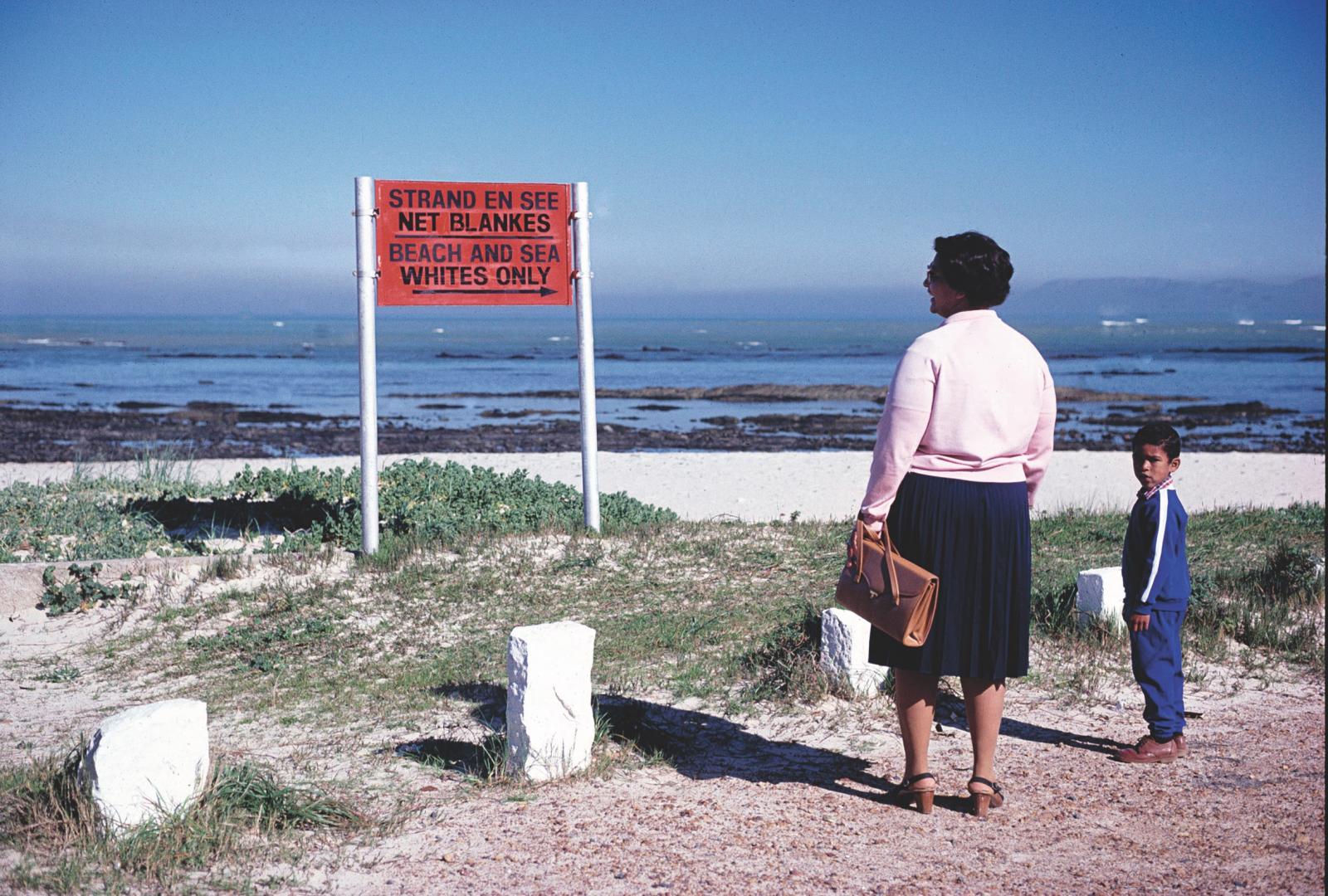 Woman and child looking at sign saying: Whites only