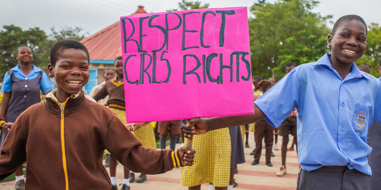 Boys holding sign: Respect girls rights