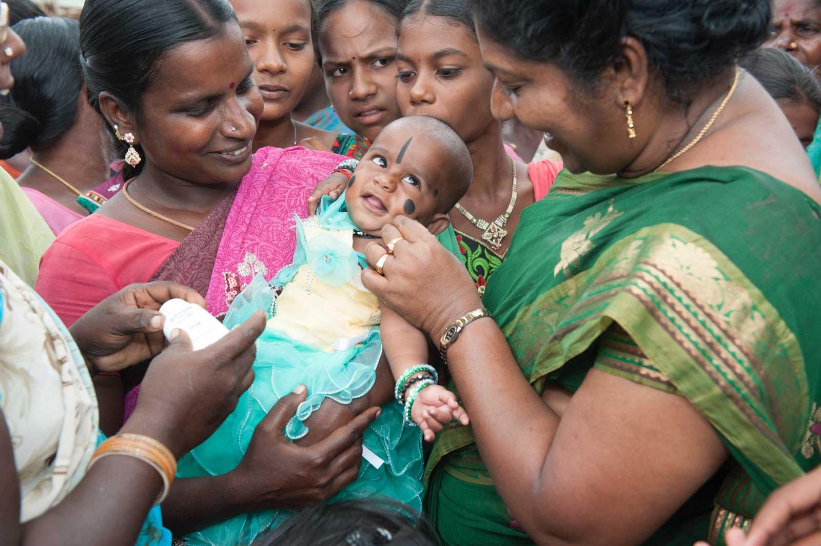 Village women put a black dot on babys forehead