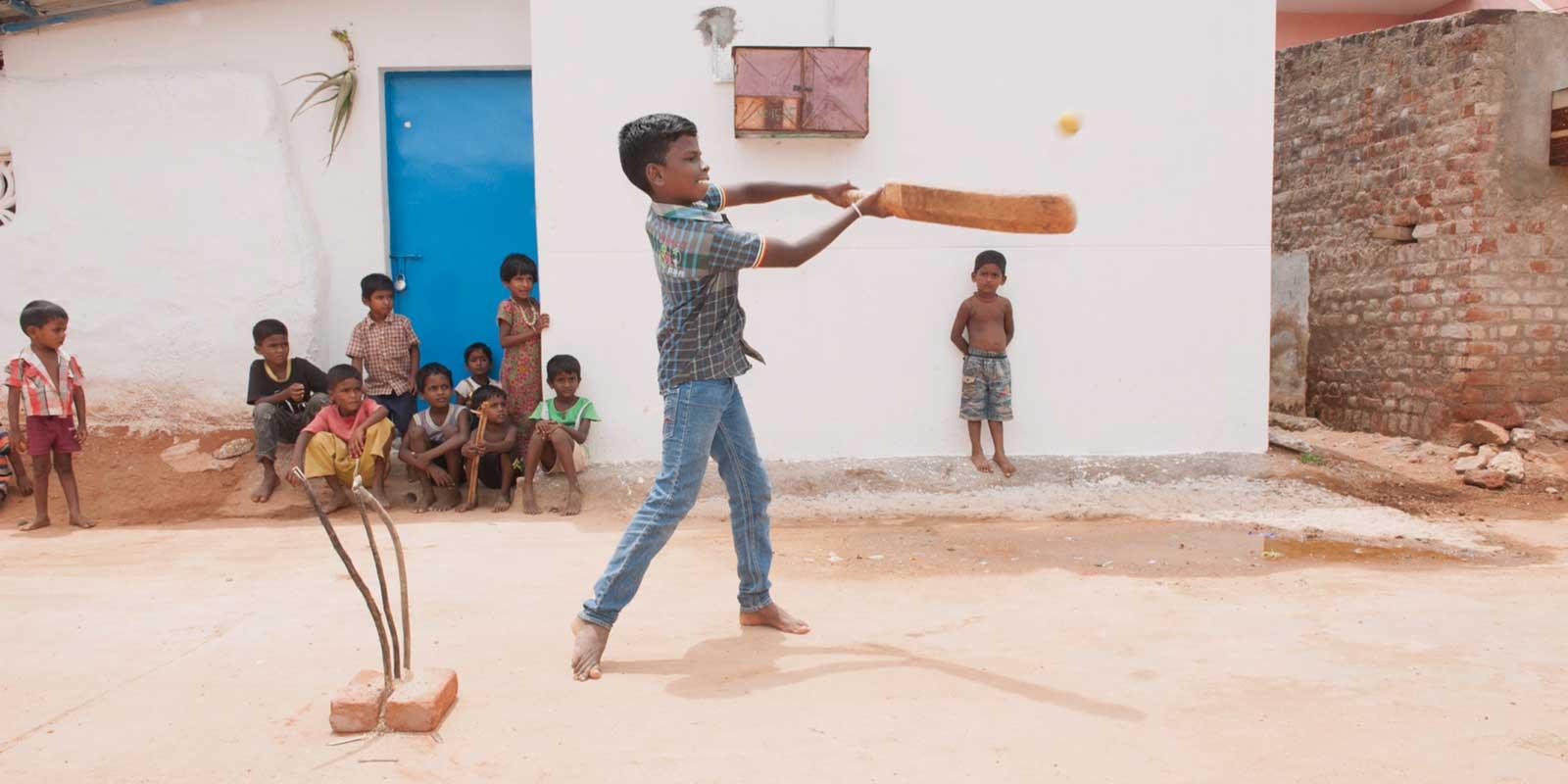 Boy hitting a cricket ball