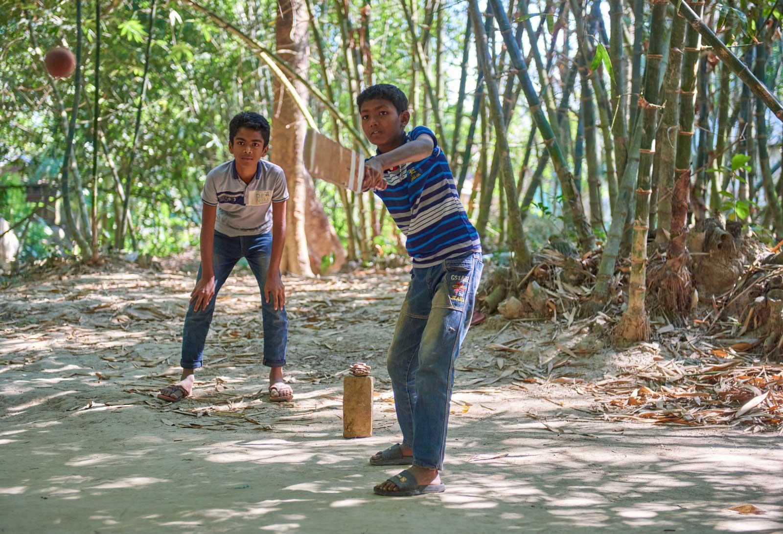 Two boys playing cricket.