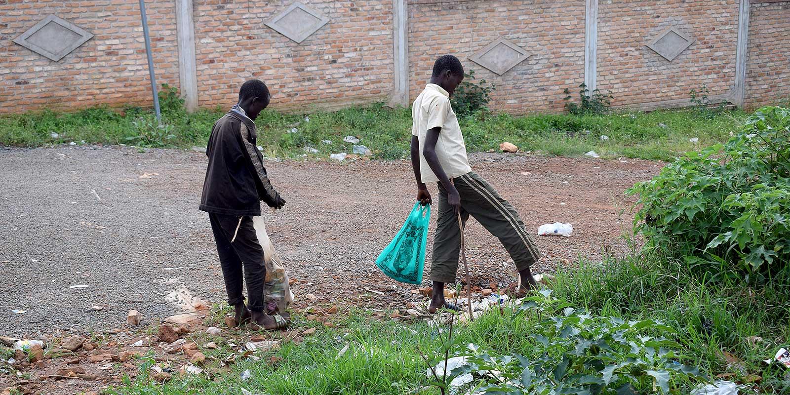 two boys collecting litter