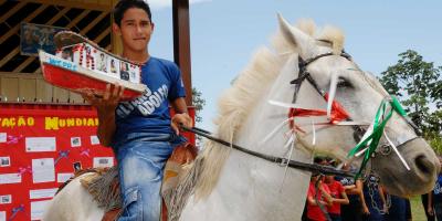 a boy with a ballot box on a horse