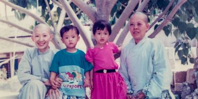 Buddhist nuns in blue dresses with two children.