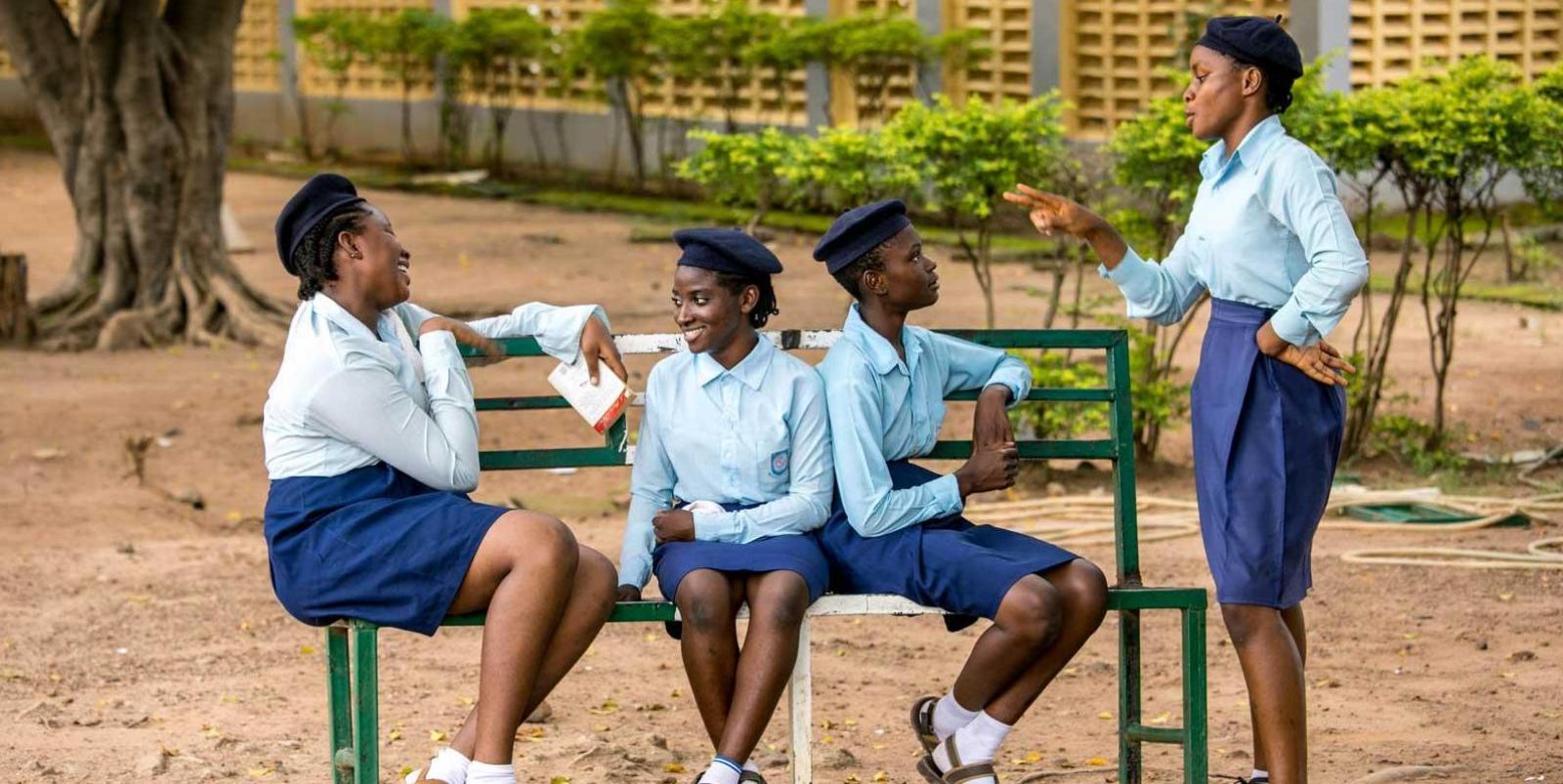 Four girls talking on a bench in NIgeria.