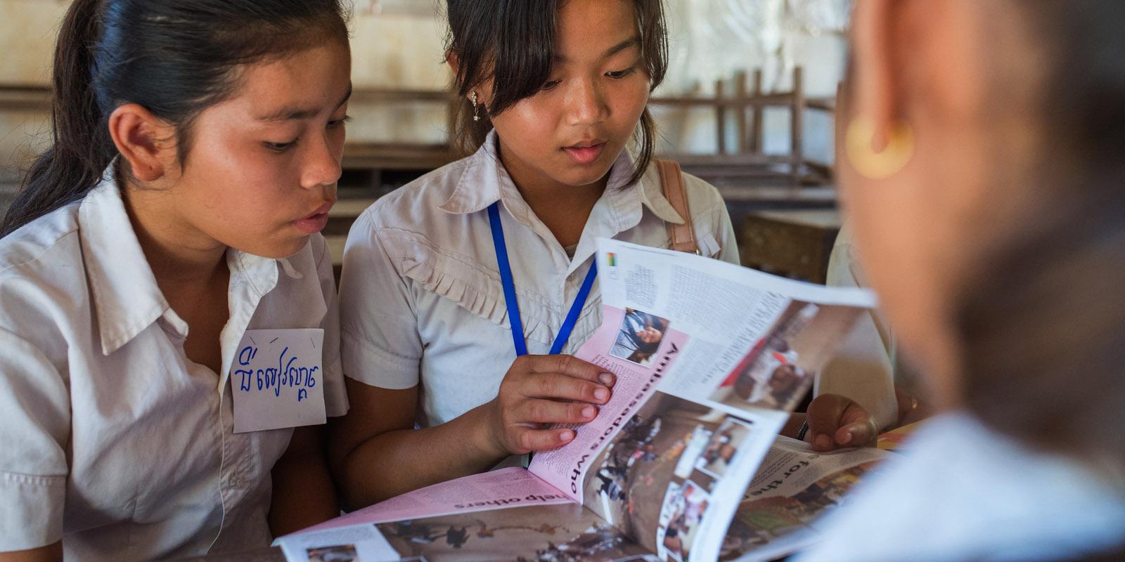 2 girls reading the Globe magazine together