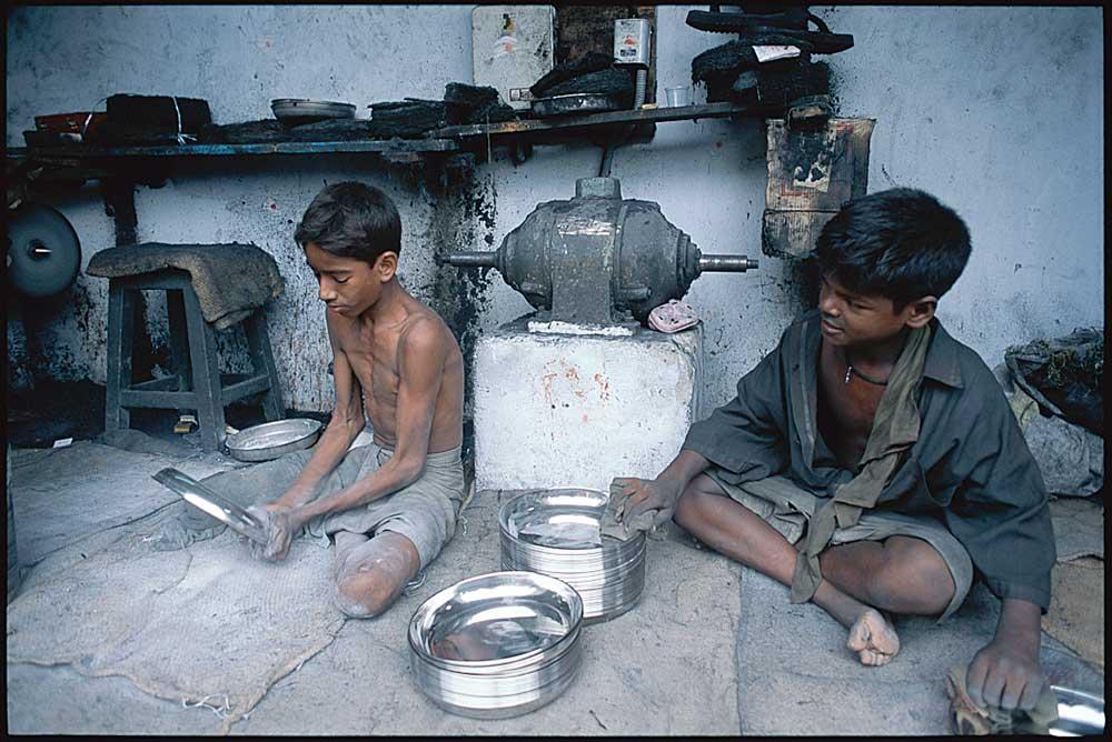 Two boys in India working in mechanics shop