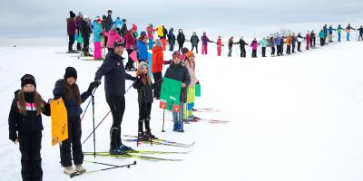 Children in Östersund, Sweden, in a long line, on skis.