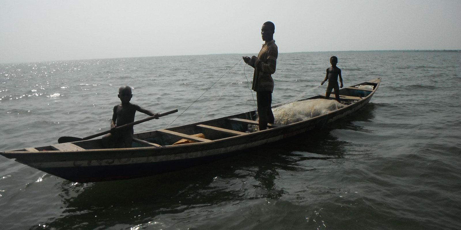 Two small boys and a man in a fishing boat