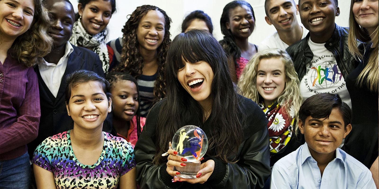 Loreen Talhaoui holding glass globe, together with children from around the world.