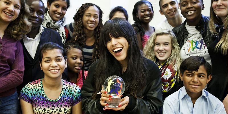 Loreen Talhaoui holding glass globe, together with children from around the world.