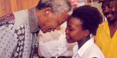 Nelson Mandela bumbing forheads with girl.