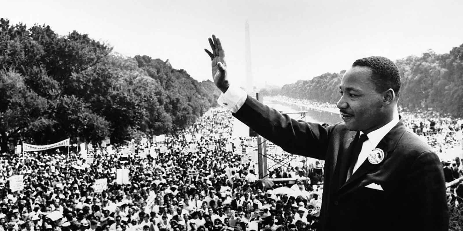 Martin Luther King waving to a crowd