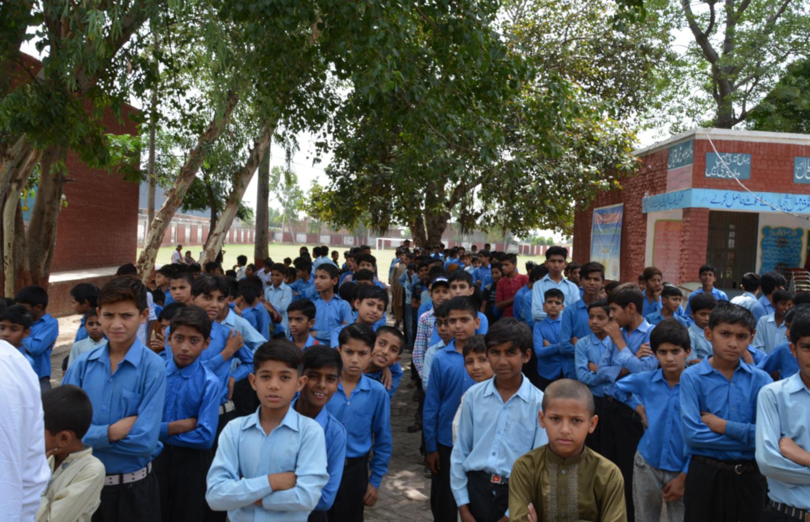 Children in blue shirts standing together facing the camera