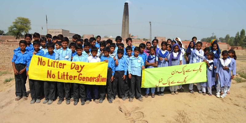 Children standing with signs saying No Litter Generation