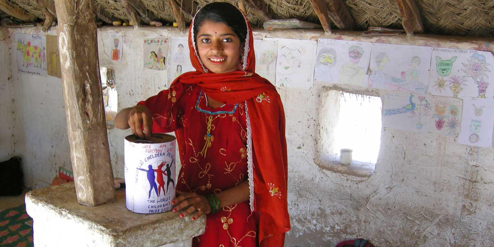 Girl putting vote in ballot box made of can