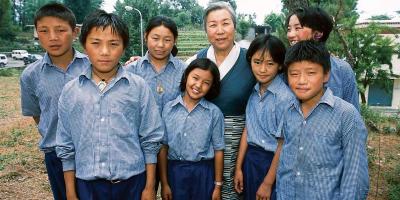 Group of Tibetan children surrounding older woman in Chupa, Jetsun Pema.
