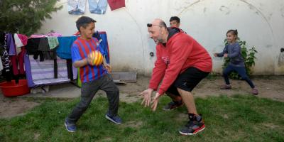 Valeriu playing football with children