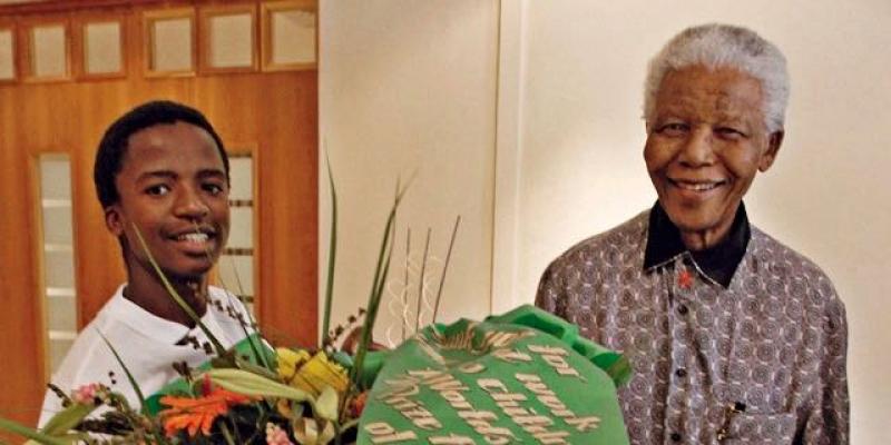 Xola holding flowers, next to Nelson Mandela